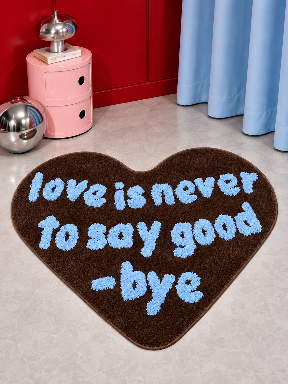 Brown heart-shaped accent rug with blue lettering on a room floor