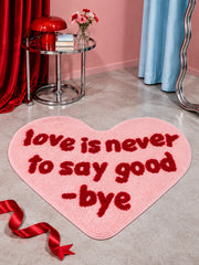 Pink heart-shaped accent rug with red lettering on a living room floor