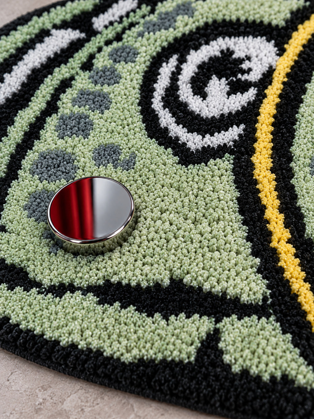 Close-up of the Rolled Cash Bath Mat's green and black tufted texture