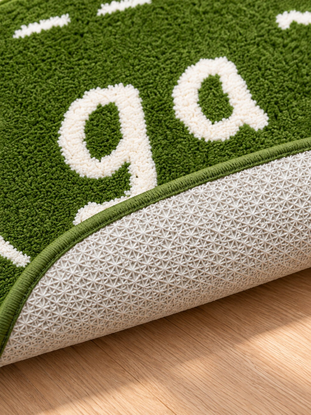 Close-up of the TPE backing of Goose Talk Green Oval Bath Mat & Runner Rug