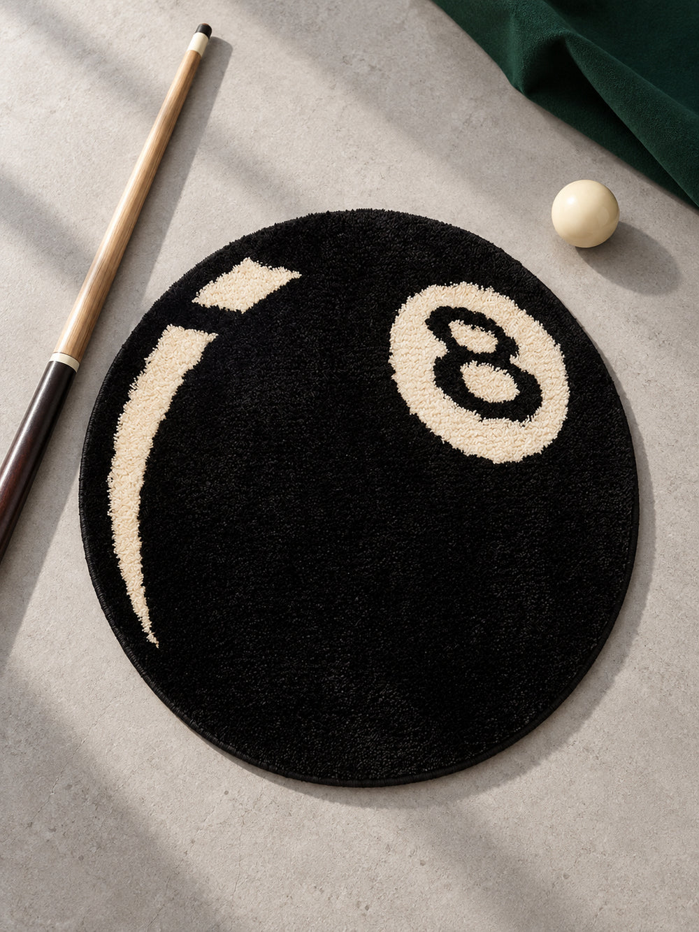 Black eight-ball round rug, 40 cm diameter, viewed from above beside a pool cue and billiard ball.