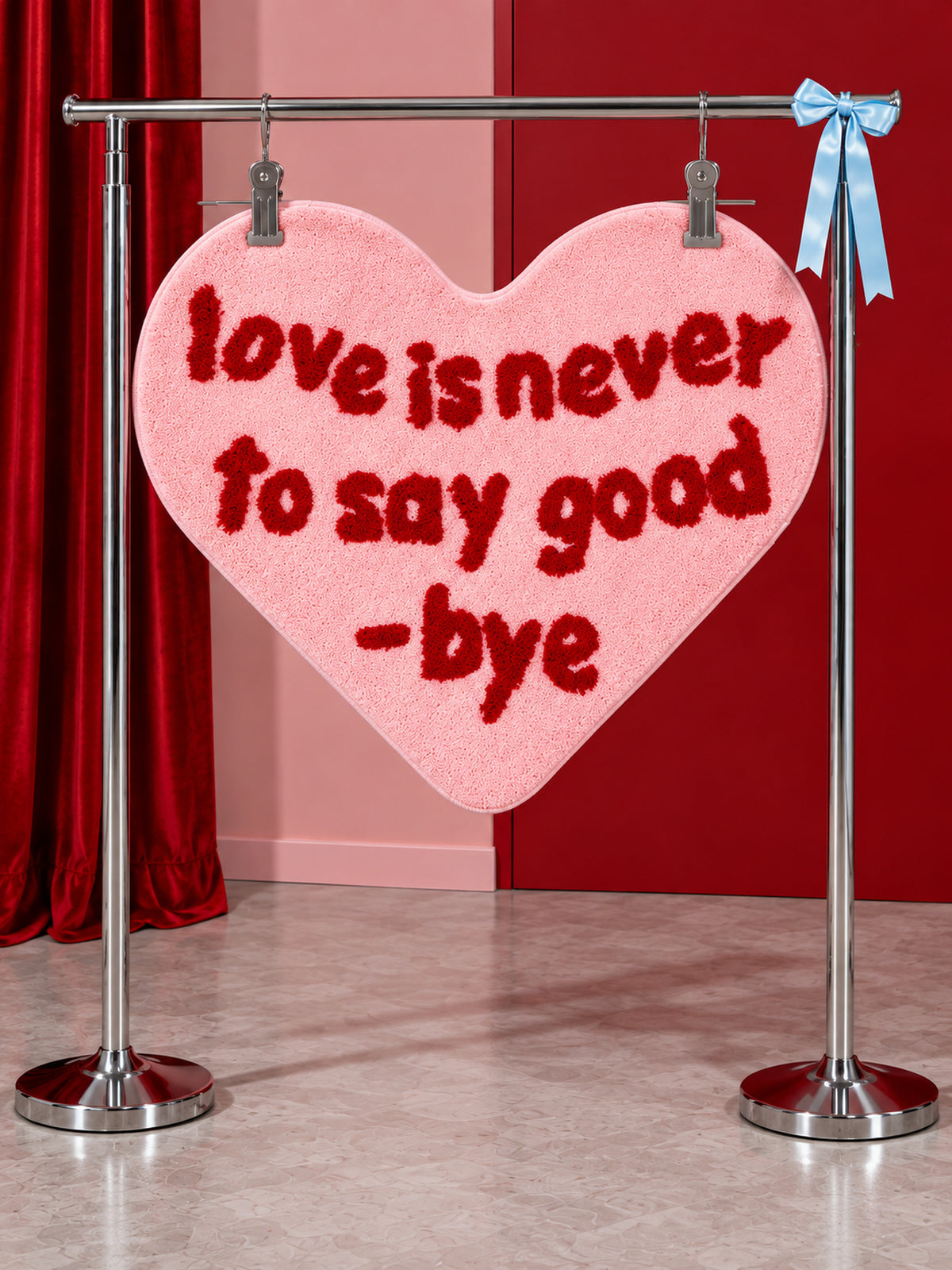 Pink heart-shaped accent rug hanging from a display rail