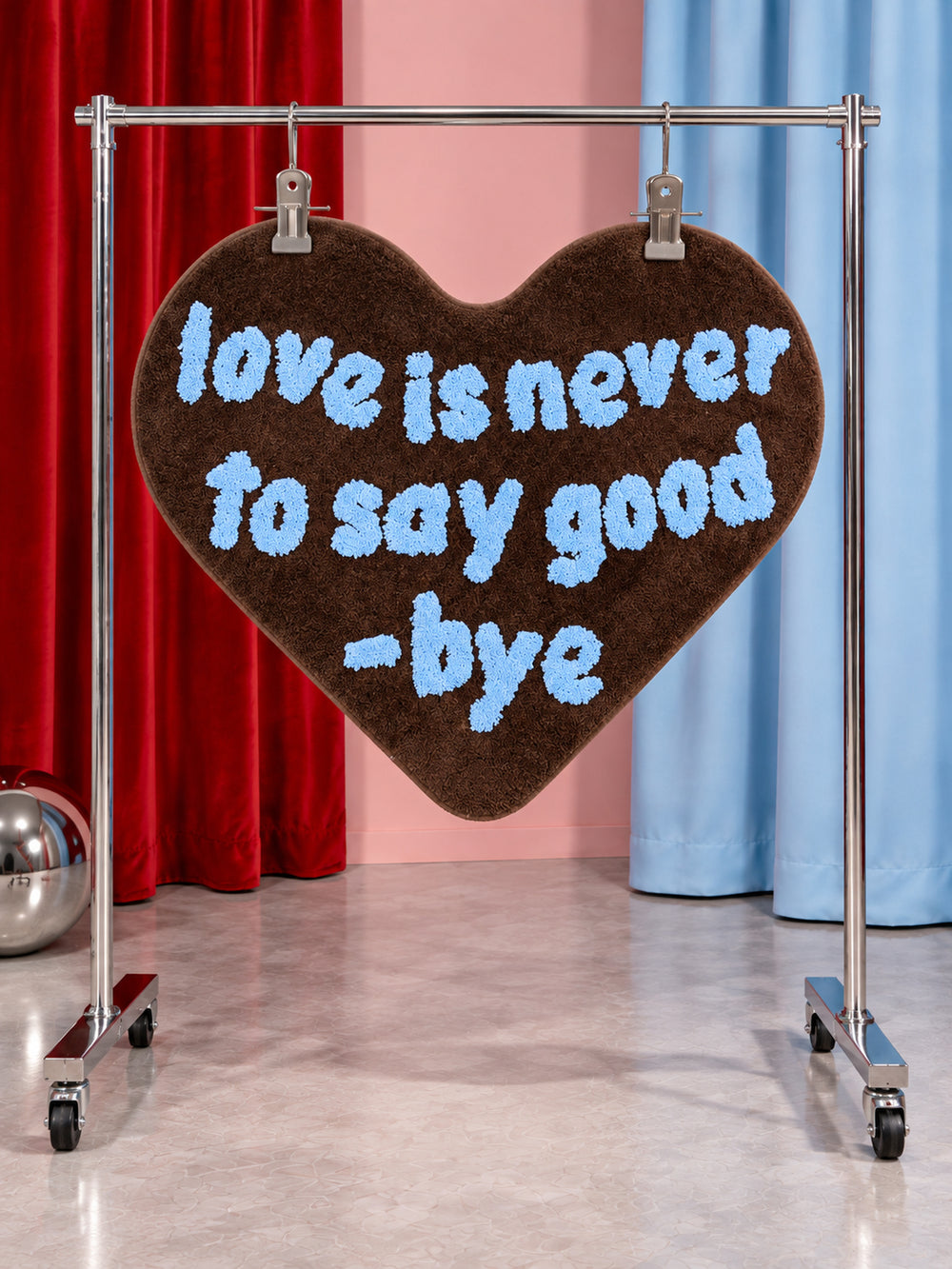 Brown heart-shaped accent rug hanging from a display rail