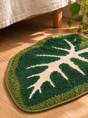 Alocasia Leaf Tropical Green Bath Mat beside a bed, shown from another angle