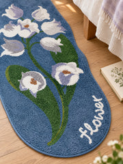 Midnight Garden Blue Floral Bath Mat beside a bed, shown from another angle