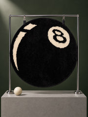 Black eight-ball round rug, 40 cm diameter, hanging from a metal display frame.