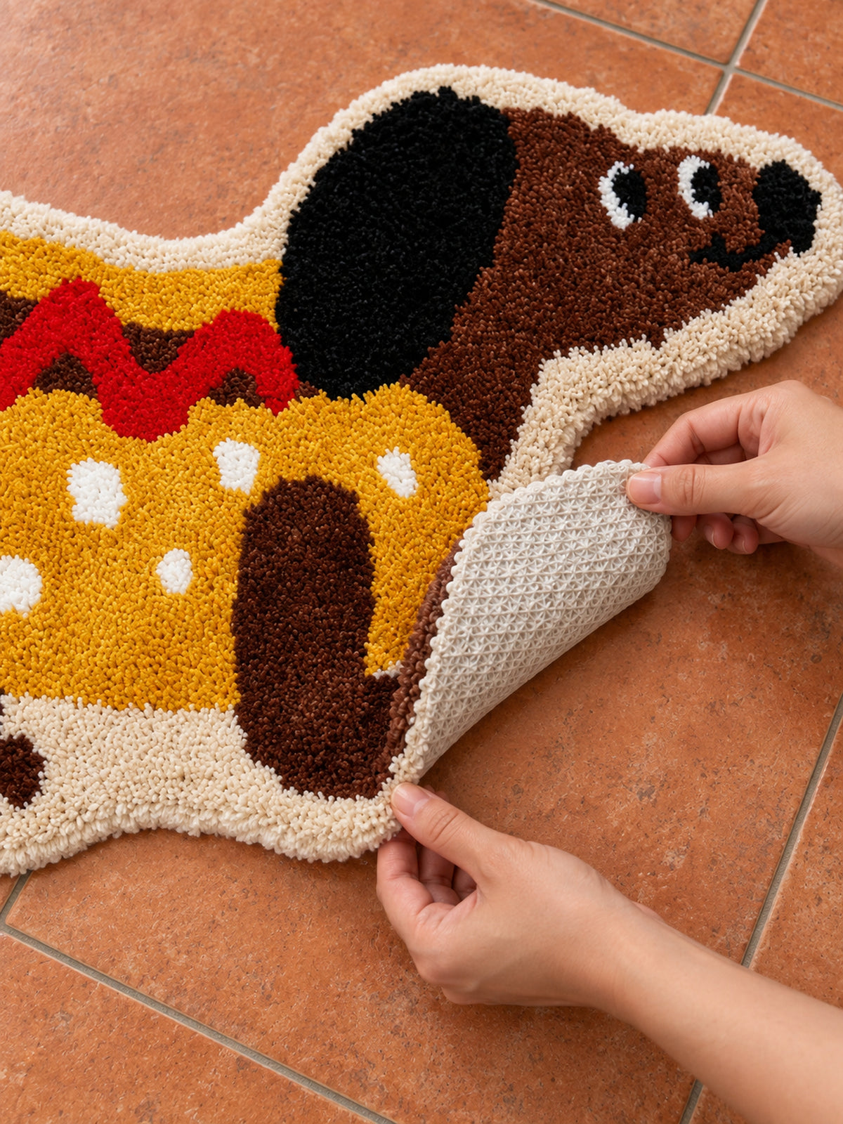 Hot dog dachshund-shaped rug, 80 x 160 cm, with an edge lifted to show the pale patterned backing.