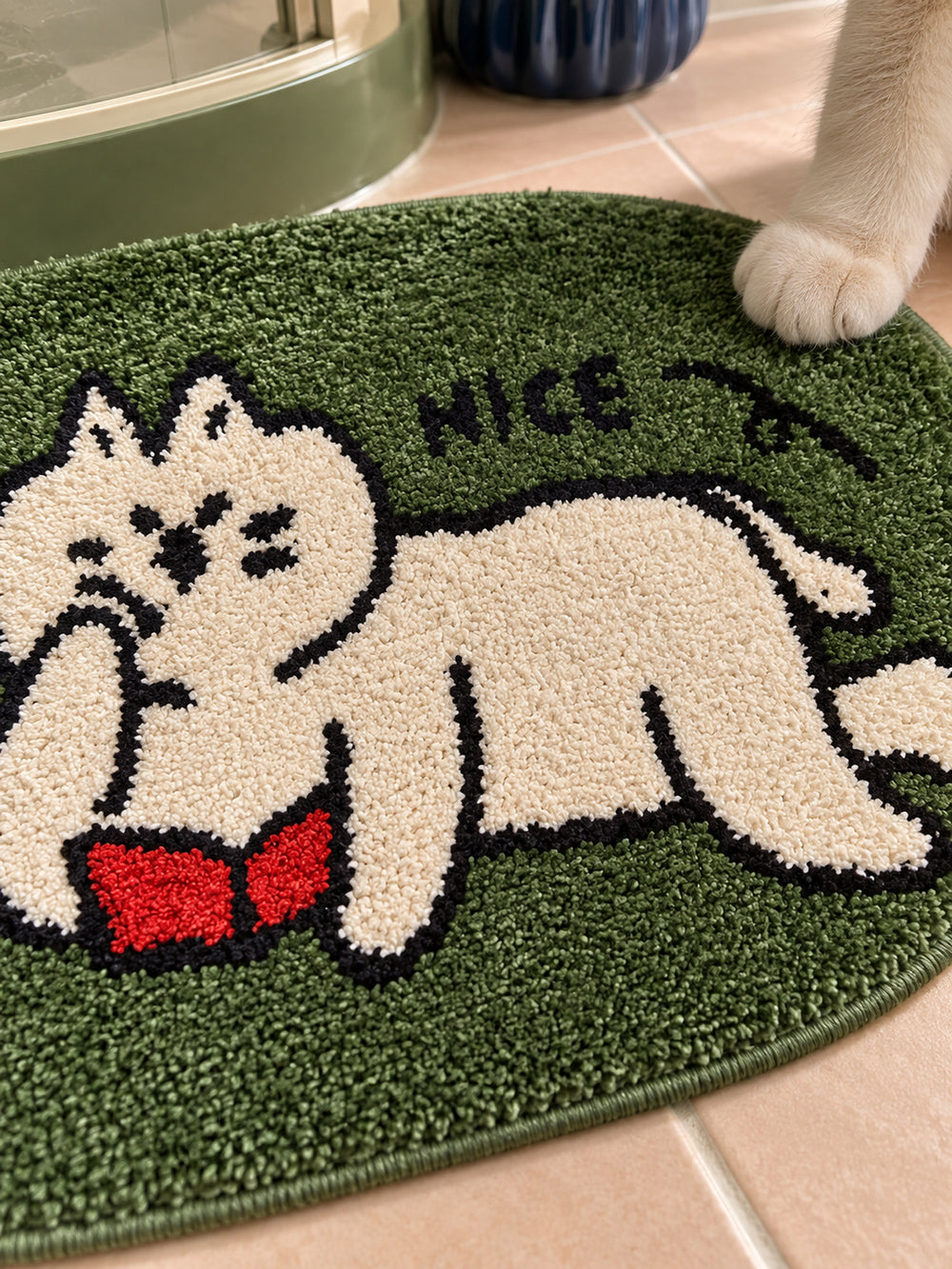 Green reading-cat oval mat, 50 x 80 cm, close-up of the cat, red book and NICE lettering.