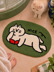 Green reading-cat oval mat, 50 x 80 cm, viewed from above beside a cat on a bathroom floor.