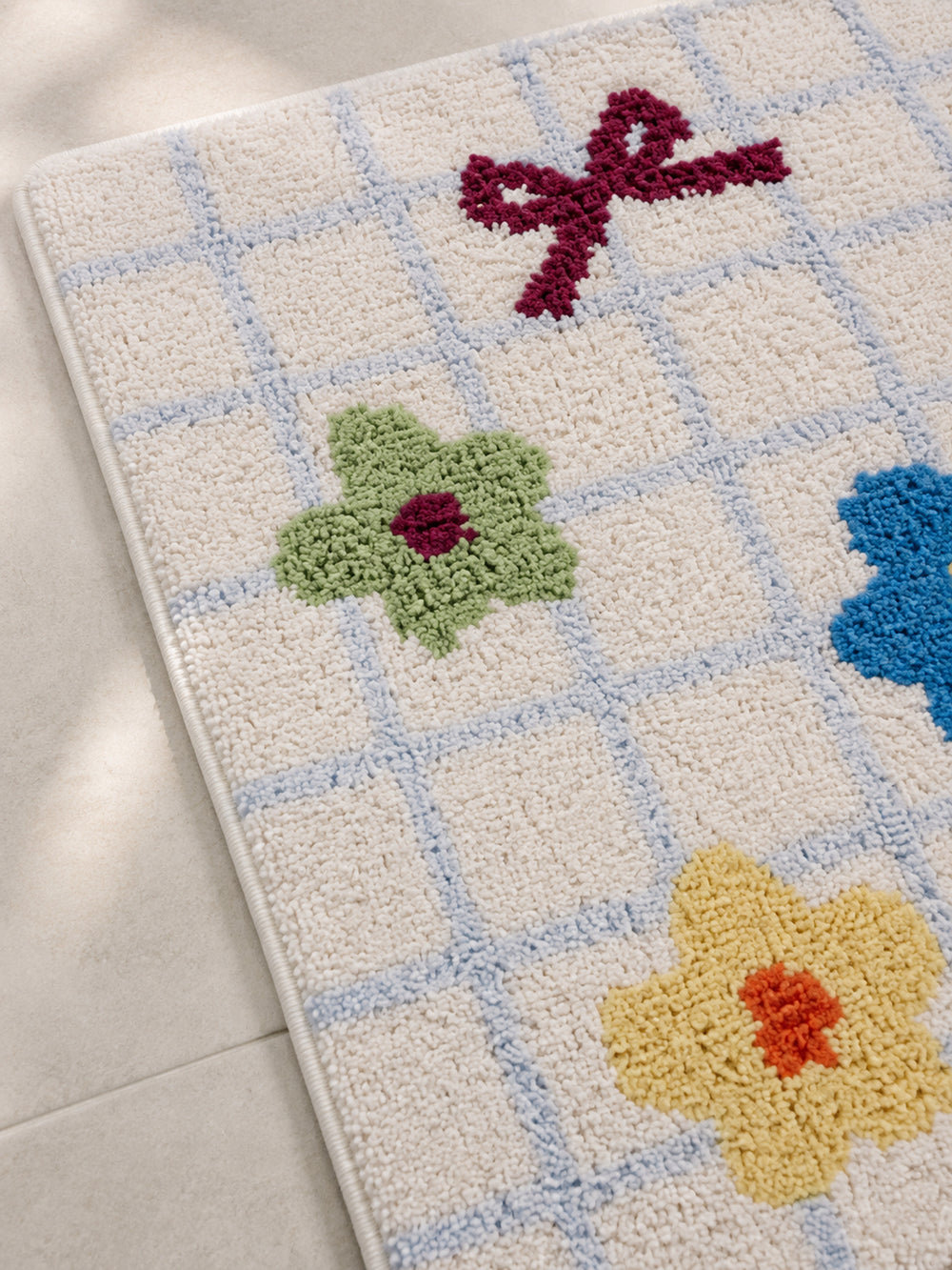 Garden Bows and Blooms checkered mat, 50 x 80 cm, close-up of colorful bows, flowers and blue grid lines.