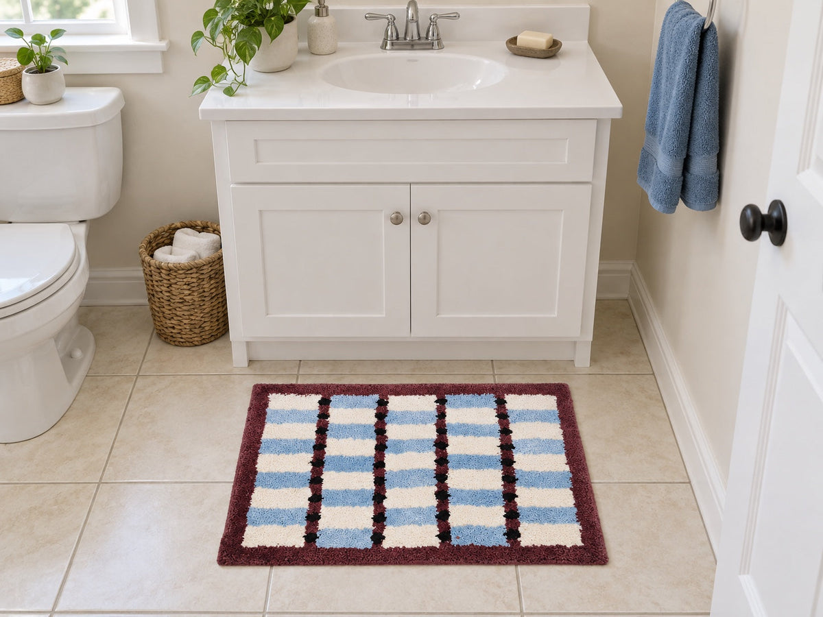A compact LivingFun Sky Cocoa Grid rectangular bath mat aligned with a white vanity in a small bathroom.