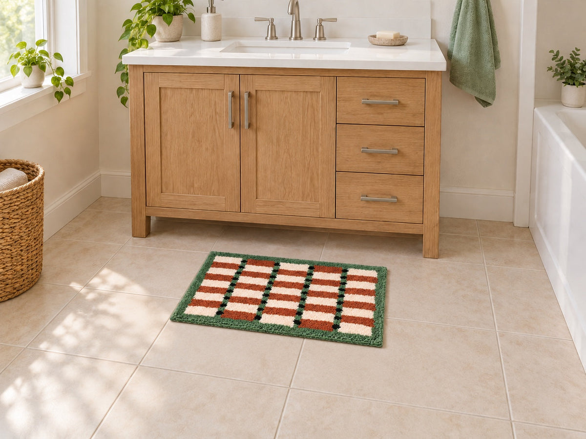 AI styling illustration of a compact 40 by 60 cm Sage Cocoa Grid bath mat with visible floor around it at a single vanity