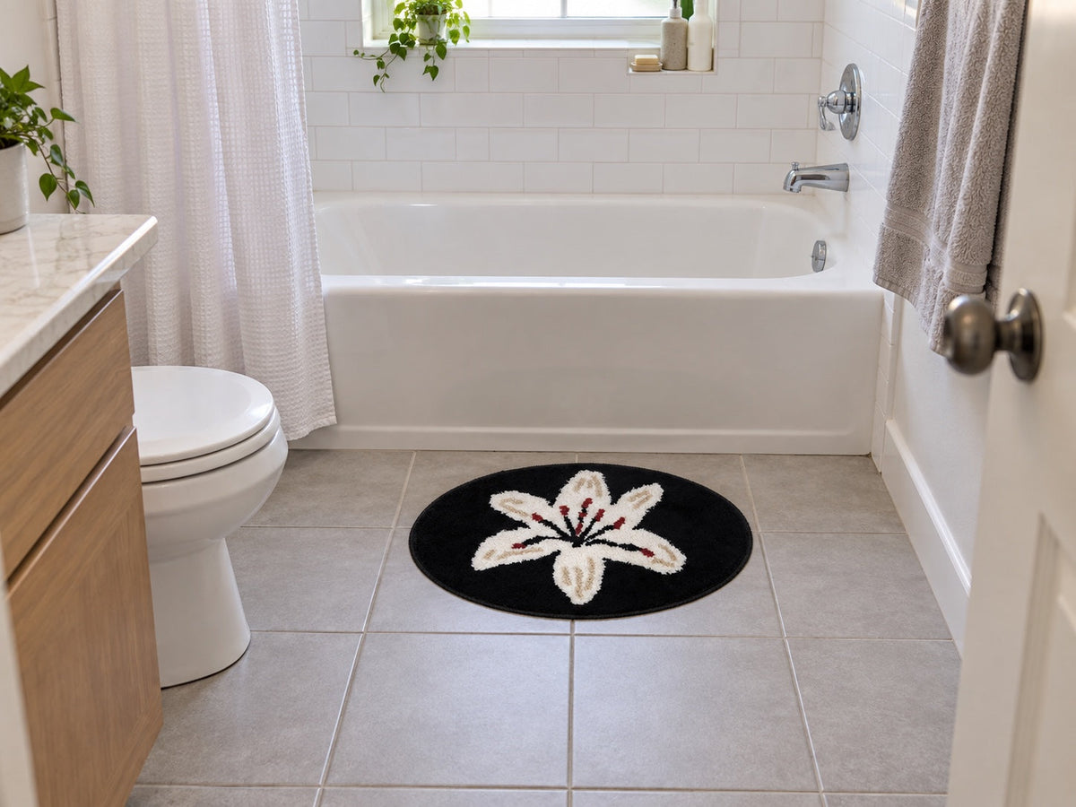 A compact black LivingFun lily bath mat beside a white tub in a small everyday American bathroom.