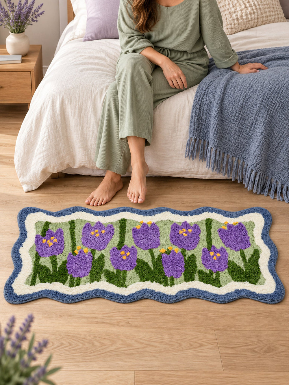 Violet Tulip Frame Wavy-Edge Bath Mat & Runner Rug beside a bed
