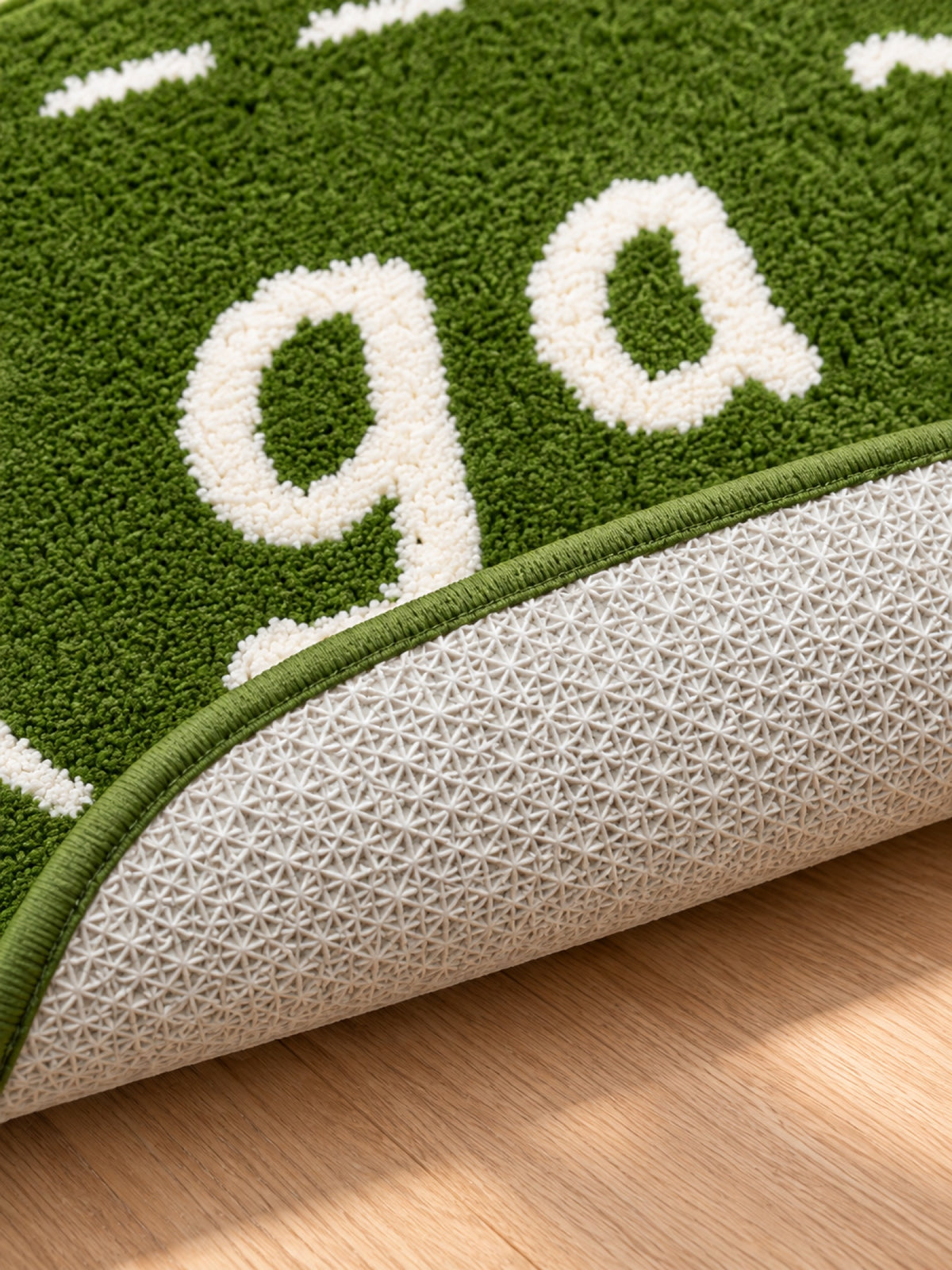 Close-up of the TPE backing of Goose Talk Green Oval Bath Mat & Runner Rug