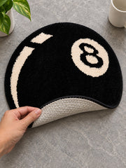 Black eight-ball round rug, 40 cm diameter, with one edge lifted to show the pale patterned backing.