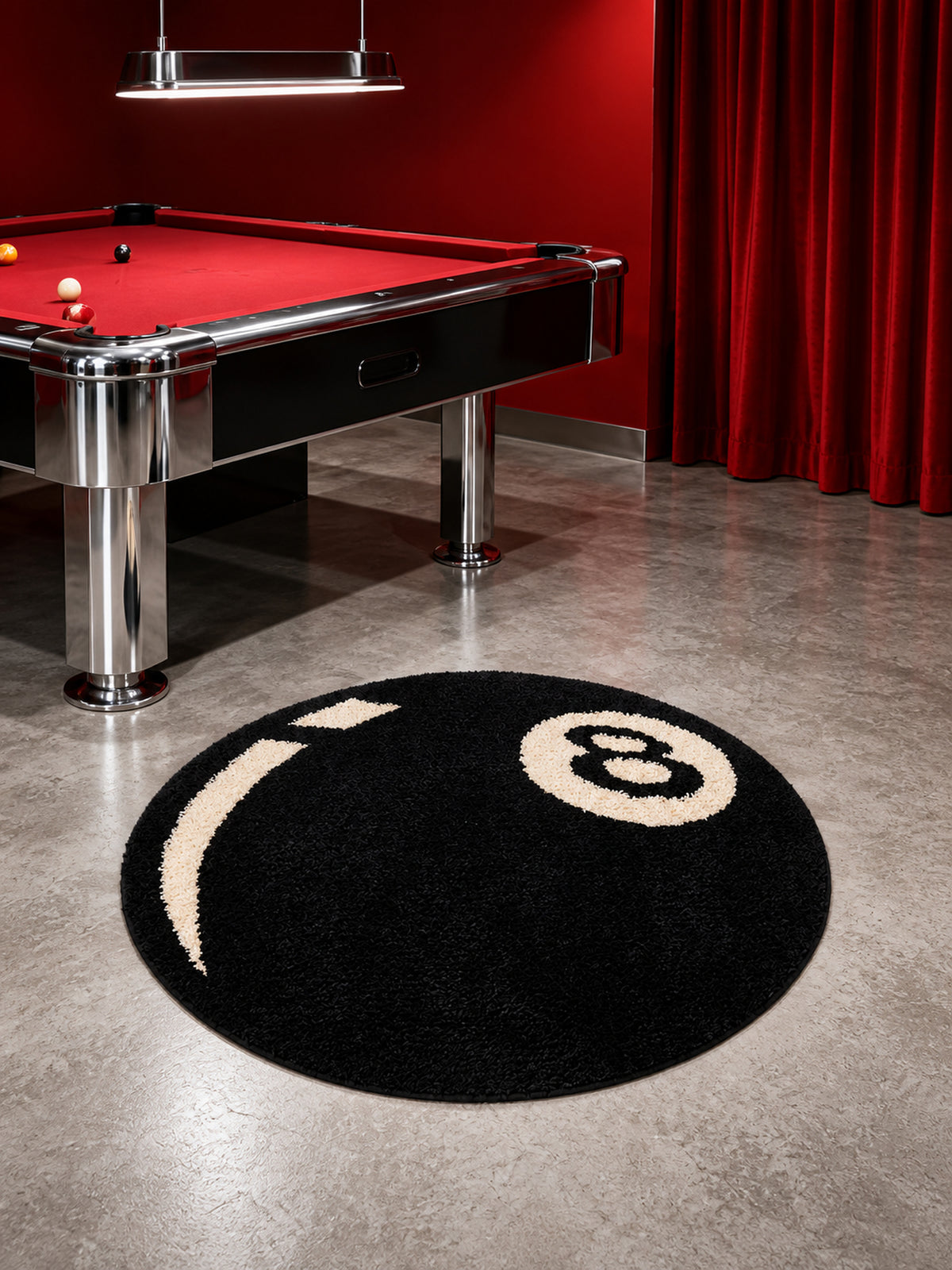 Black eight-ball round rug, 80 cm diameter, on the floor beside a red pool table.