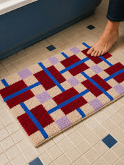 Crimson Grid Colorblock Bath Mat on a bathroom floor, shown from another angle