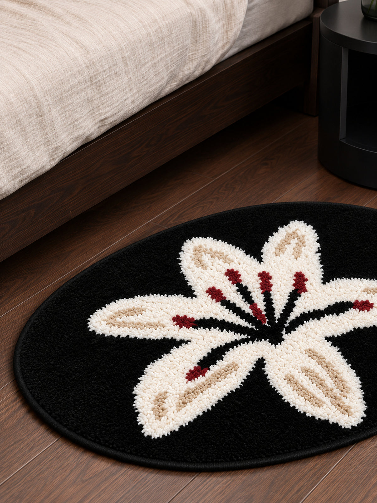 Midnight Lily Oval Bath Mat beside a bed, shown from another angle