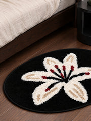 Midnight Lily Oval Bath Mat beside a bed, shown from another angle