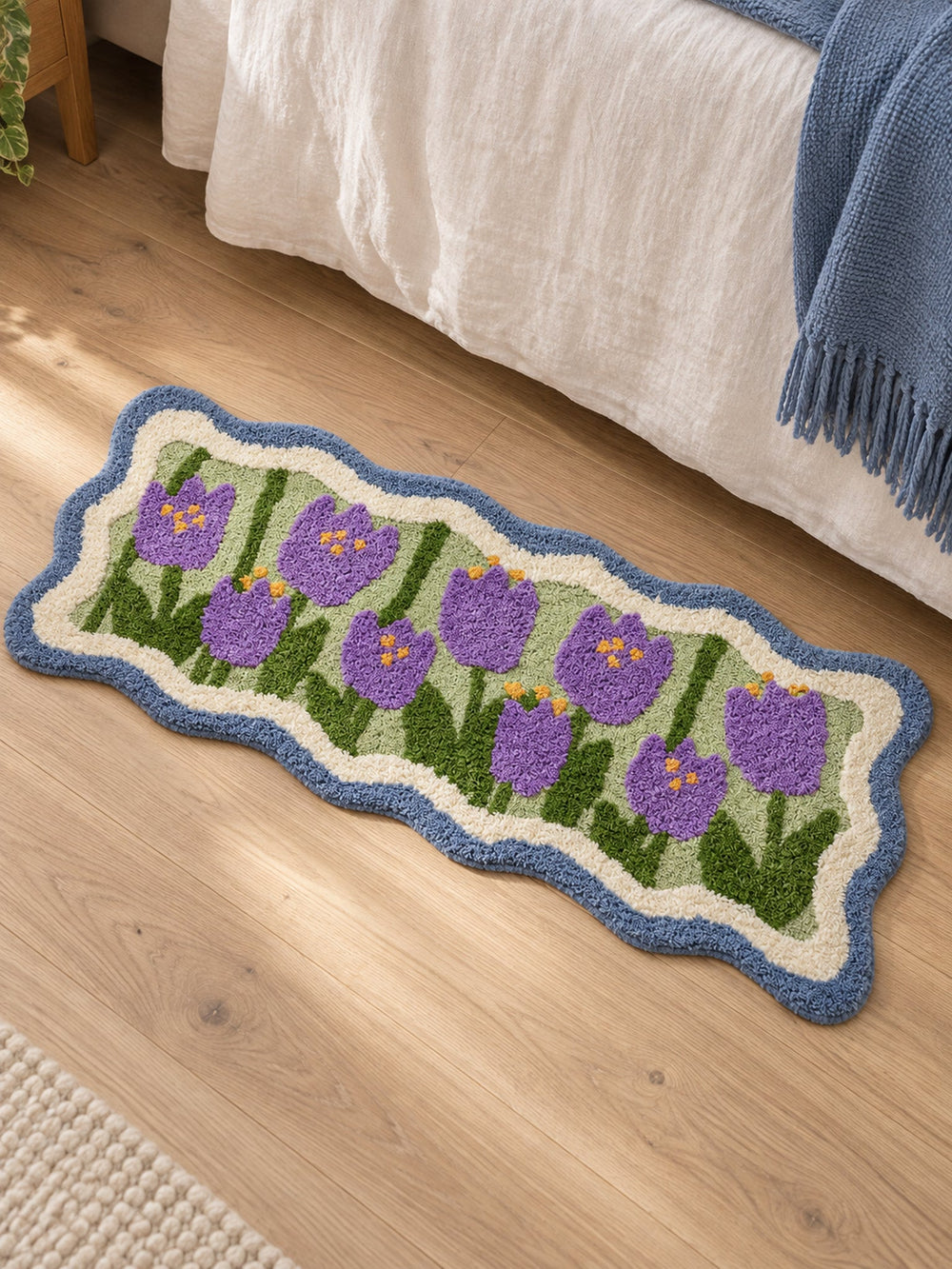 Violet Tulip Frame Wavy-Edge Bath Mat & Runner Rug beside a bed, shown from another angle