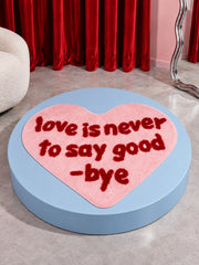Pink heart-shaped accent rug displayed on a blue round platform