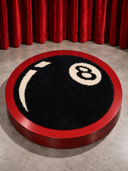 Black eight-ball round rug, 80 cm diameter, displayed on a red circular platform.