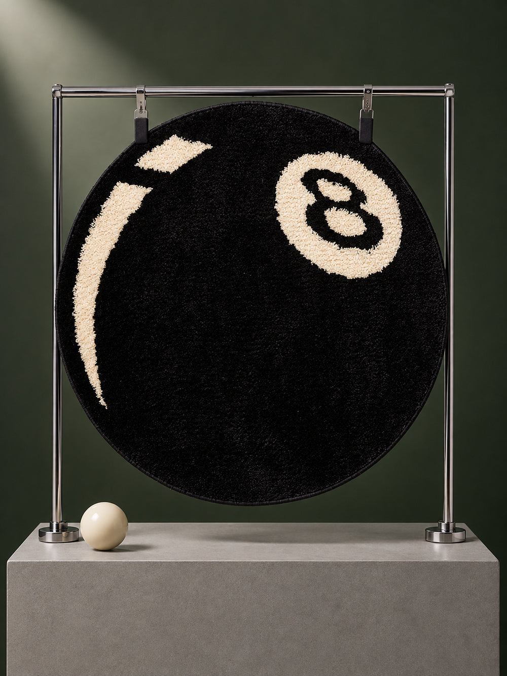 Black eight-ball round rug, 40 cm diameter, hanging from a metal display frame.