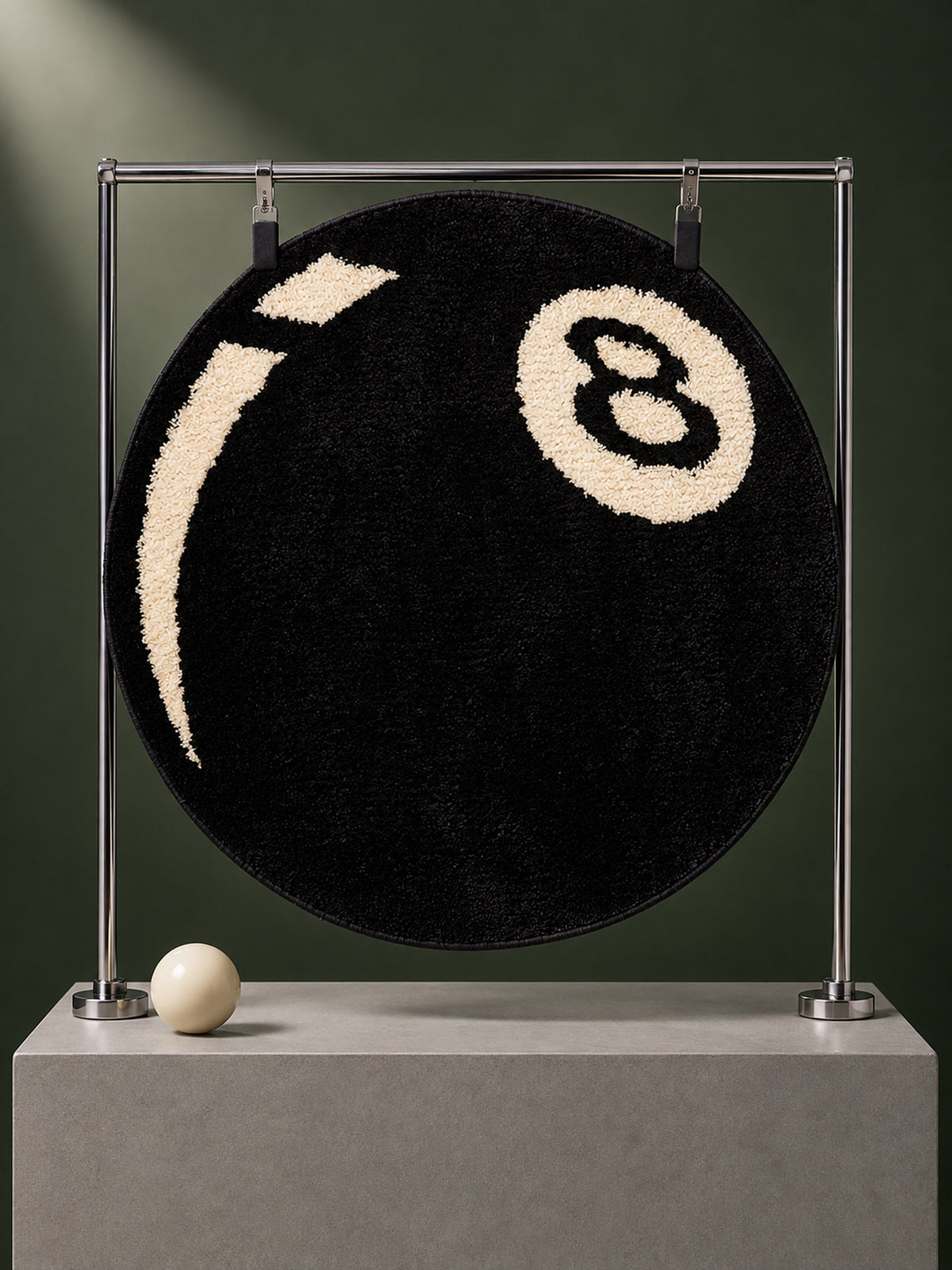Black eight-ball round rug, 40 cm diameter, hanging from a metal display frame.