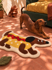 Hot dog dachshund-shaped rug, 80 x 160 cm, beside a dachshund and green bed in warm sunlight.