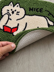 Green reading-cat oval mat, 50 x 80 cm, with one edge lifted to show the pale patterned backing.