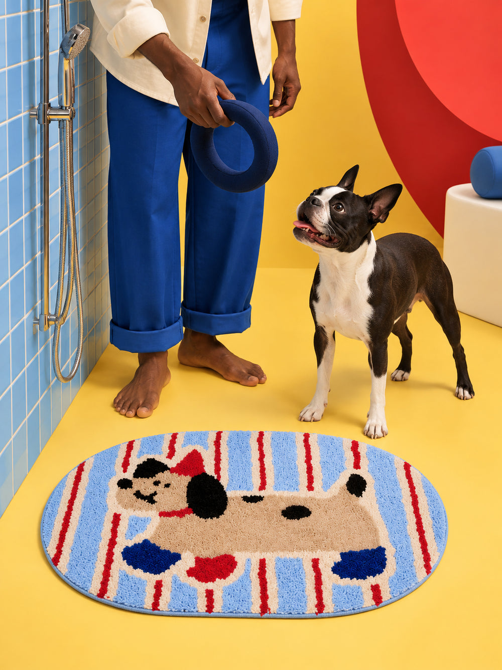 Blue and red striped playful pup mat, 50 x 80 cm, beside a person and dog in a colorful shower area.