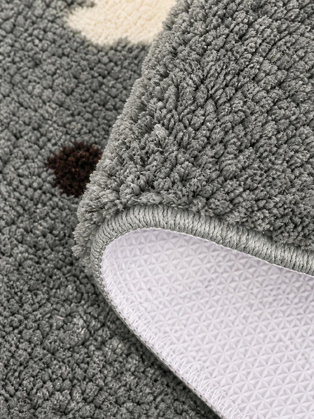Gray polka-dot pup oval mat, 50 x 80 cm, with its edge folded to reveal the pale patterned backing.