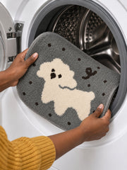 Gray polka-dot pup oval mat, 50 x 80 cm, held at the open door of a front-loading washing machine.